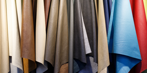 Couros para produção de roupas pendurados, em cores azul, marrom, preto, vermelho